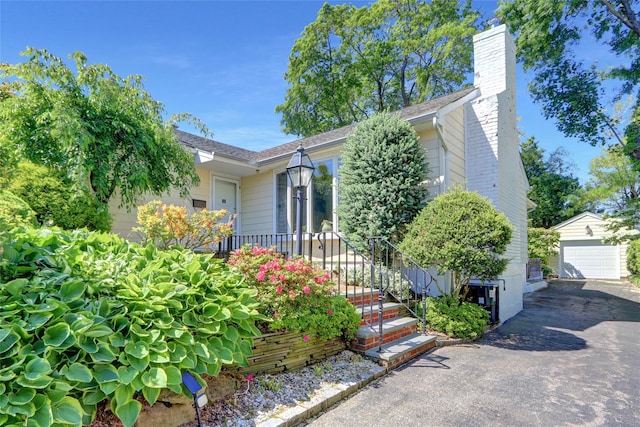 1 Exeter Pl, Glen Head, NY 11545 - view of front of house with an outdoor structure, a chimney, and a garage