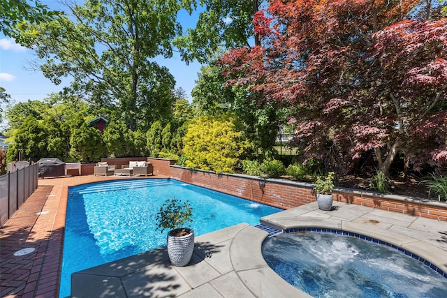 swimming pool with an in-ground hot tub, an outdoor hangout area, and a patio area