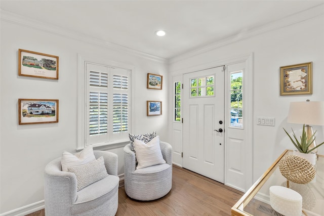 entrance foyer with wood finished floors, crown molding, recessed lighting, and baseboards