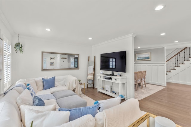 living room with stairway, wood finished floors, ornamental molding, and recessed lighting