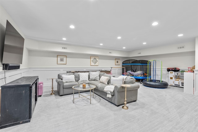living room featuring carpet floors, wainscoting, and recessed lighting