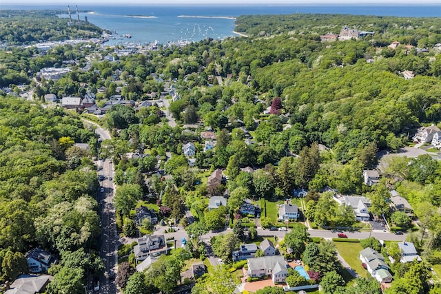 aerial view of property's location with a nearby body of water and a heavily wooded area