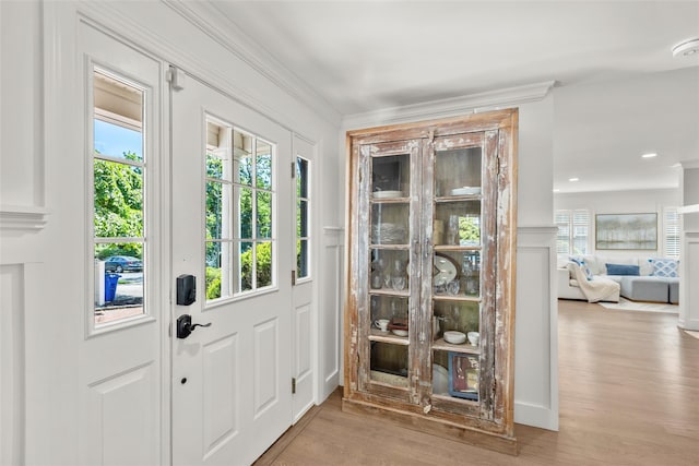 foyer entrance featuring wood finished floors and crown molding