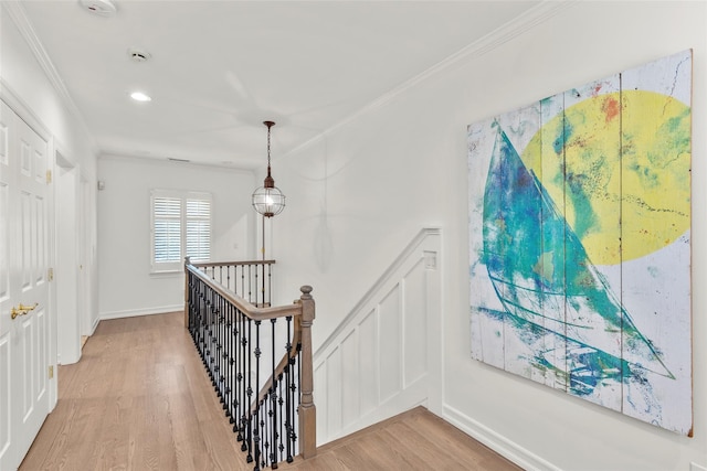 corridor featuring an upstairs landing, crown molding, light wood-style floors, recessed lighting, and baseboards