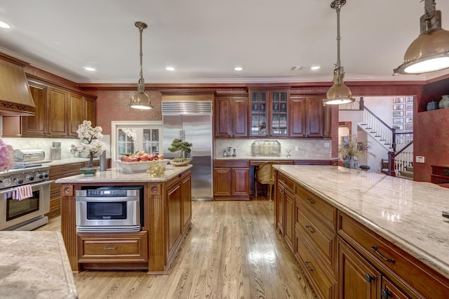7 Cedar Ln, Glen Cove, NY 11542 - kitchen with high end appliances, backsplash, light wood finished floors, light stone countertops, and ornamental molding