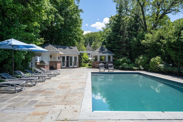 7 Cedar Ln, Glen Cove, NY 11542 - swimming pool with a gazebo, a storage structure, a patio area, an outdoor structure, and french doors