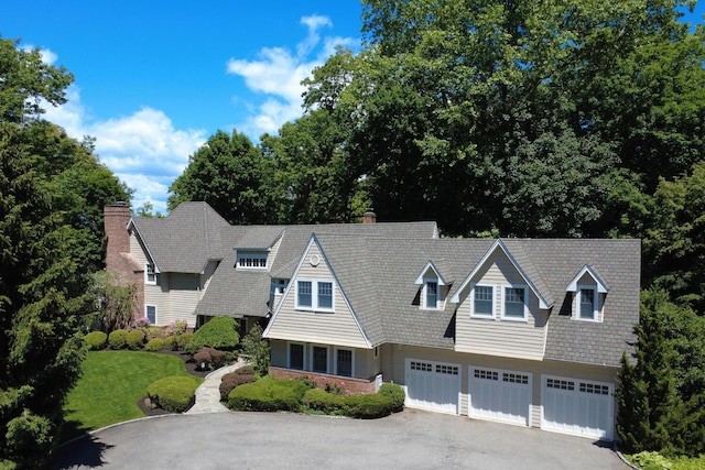 7 Cedar Ln, Glen Cove, NY 11542 - shingle-style home featuring an attached garage, asphalt driveway, a chimney, and a front yard
