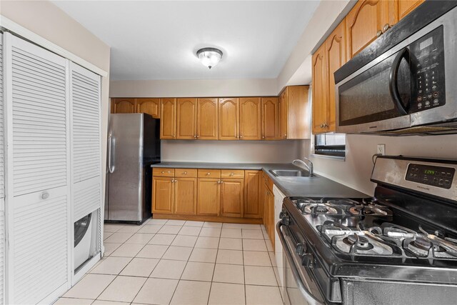 120-15 Cove Ct Unit 90A, College Point, NY 11356 - kitchen featuring appliances with stainless steel finishes, a sink, brown cabinets, and light tile patterned floors