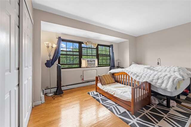 120-15 Cove Ct Unit 90A, College Point, NY 11356 - bedroom with light wood-style flooring, a closet, cooling unit, and a baseboard radiator