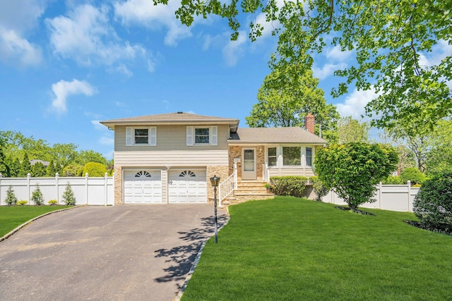 tri-level home featuring driveway, an attached garage, a chimney, and stone siding