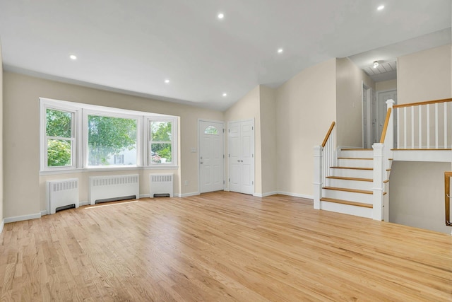 unfurnished living room with radiator, stairs, recessed lighting, wood finished floors, and vaulted ceiling