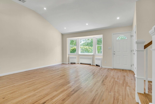 foyer entrance with radiator, light wood finished floors, lofted ceiling, baseboards, and recessed lighting