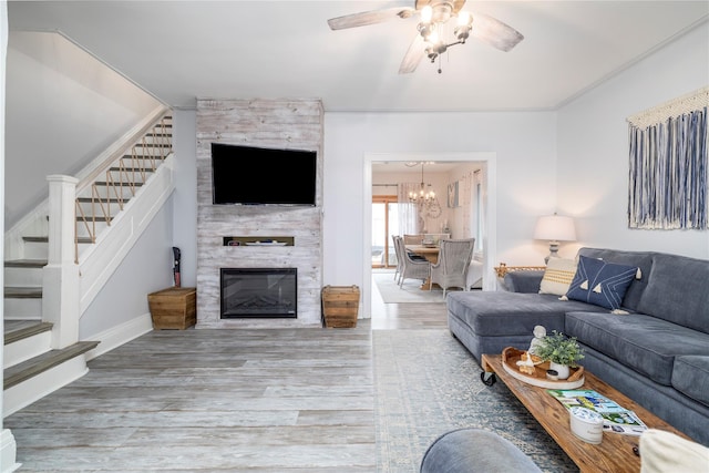 630 W Chester St, Long Beach, NY 11561 - living room featuring stairs, wood finished floors, ceiling fan, a fireplace, and a chandelier