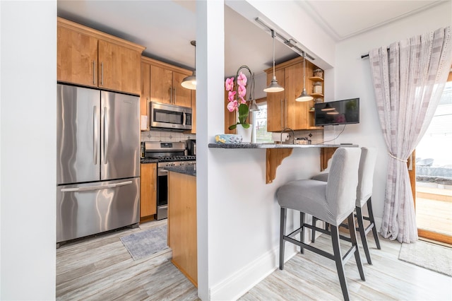 630 W Chester St, Long Beach, NY 11561 - kitchen with stainless steel appliances, light wood-style flooring, open shelves, backsplash, and a kitchen breakfast bar