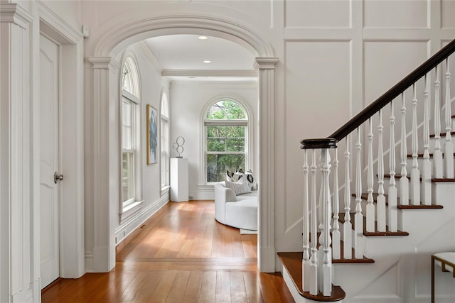 52 Carriglea Dr, Call Listing Agent, CT 06878 - foyer featuring wood-type flooring, crown molding, arched walkways, and stairs