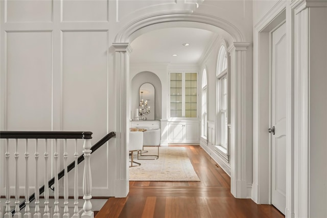 52 Carriglea Dr, Call Listing Agent, CT 06878 - hallway featuring a decorative wall, arched walkways, wood finished floors, ornamental molding, and ornate columns