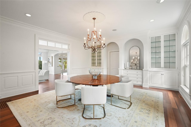 52 Carriglea Dr, Call Listing Agent, CT 06878 - dining area featuring a chandelier, arched walkways, crown molding, dark wood-style floors, and a decorative wall