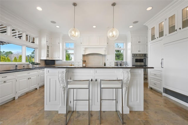 52 Carriglea Dr, Call Listing Agent, CT 06878 - kitchen featuring dark countertops, a sink, white cabinets, a breakfast bar, and recessed lighting