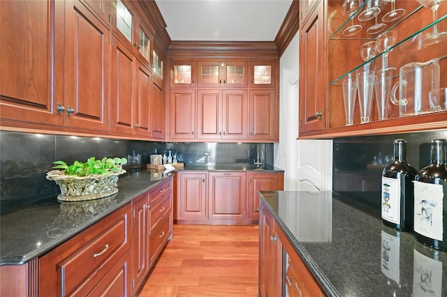 52 Carriglea Dr, Call Listing Agent, CT 06878 - kitchen with backsplash, light wood-style floors, glass insert cabinets, and dark stone counters