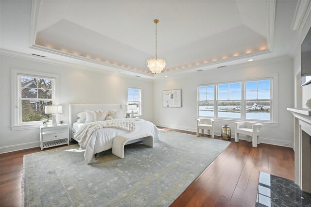 52 Carriglea Dr, Call Listing Agent, CT 06878 - bedroom featuring a tray ceiling, ornamental molding, dark wood-style flooring, a chandelier, and a fireplace with flush hearth