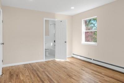8 Hilltop Ave, West Babylon, NY 11704 - unfurnished bedroom with baseboard heating, baseboards, wood finished floors, connected bathroom, and recessed lighting