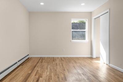 8 Hilltop Ave, West Babylon, NY 11704 - unfurnished bedroom with baseboard heating, wood finished floors, baseboards, a closet, and recessed lighting