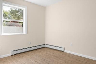 8 Hilltop Ave, West Babylon, NY 11704 - spare room with light wood-style floors, a baseboard radiator, and baseboards