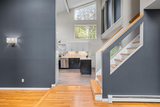 30 Apple Hill Dr, Cortlandt Manor, NY 10567 - stairway featuring a high ceiling, a baseboard radiator, wood finished floors, beam ceiling, and baseboards