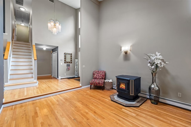 30 Apple Hill Dr, Cortlandt Manor, NY 10567 - entrance foyer featuring a wood stove, a towering ceiling, wood finished floors, stairs, and a chandelier