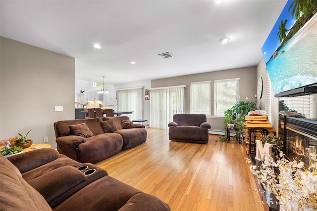 30 Apple Hill Dr, Cortlandt Manor, NY 10567 - living area featuring a glass covered fireplace, light wood-type flooring, recessed lighting, and baseboard heating