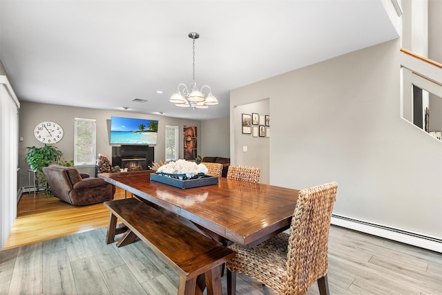 30 Apple Hill Dr, Cortlandt Manor, NY 10567 - dining area with light wood-style flooring, a baseboard heating unit, a chandelier, a glass covered fireplace, and recessed lighting