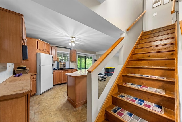 30 Apple Hill Dr, Cortlandt Manor, NY 10567 - kitchen with freestanding refrigerator, brown cabinetry, decorative backsplash, and light countertops