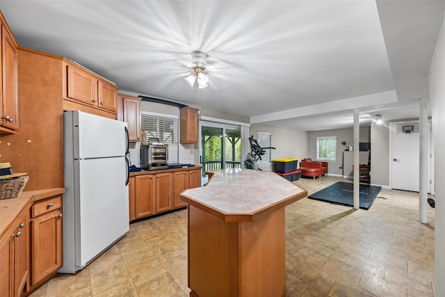 30 Apple Hill Dr, Cortlandt Manor, NY 10567 - kitchen with freestanding refrigerator, ceiling fan, open floor plan, a kitchen island, and brown cabinets