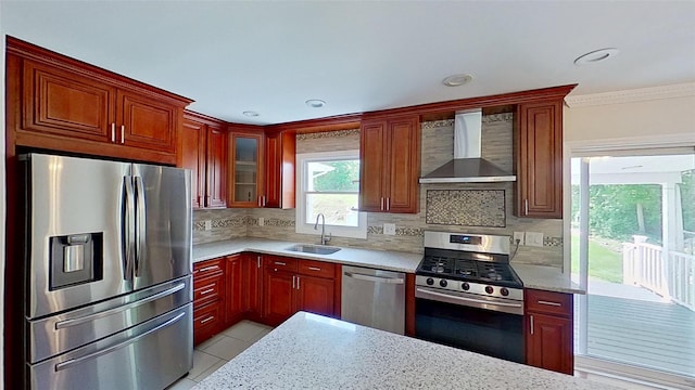 kitchen with appliances with stainless steel finishes, wall chimney range hood, a sink, decorative backsplash, and glass insert cabinets