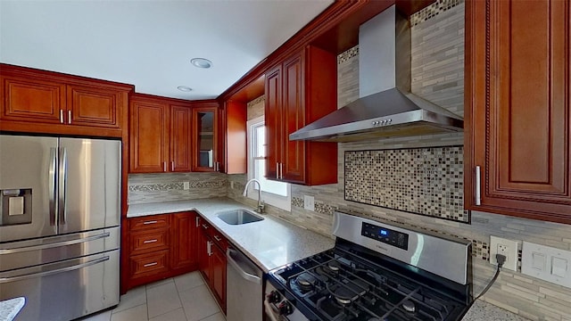 kitchen with appliances with stainless steel finishes, wall chimney exhaust hood, a sink, light countertops, and backsplash