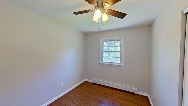 spare room featuring a baseboard heating unit, dark wood finished floors, baseboards, and a ceiling fan