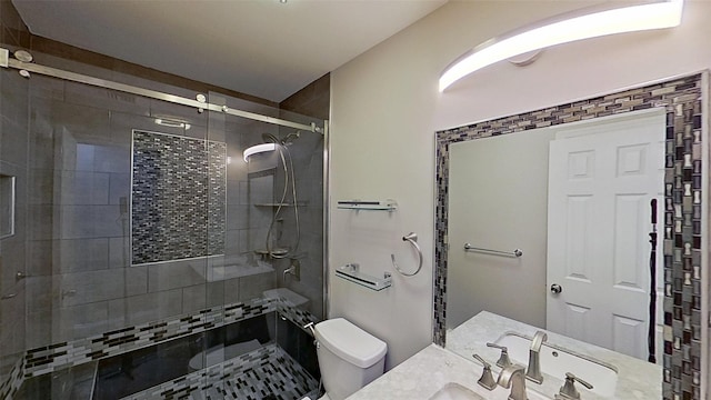 full bath featuring toilet, a stall shower, and vanity