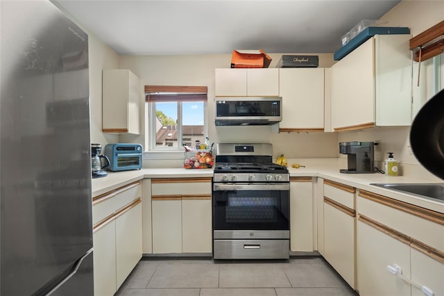 324 N Greeley Ave, Chappaqua, NY 10514 - kitchen featuring stainless steel appliances, light countertops, light tile patterned flooring, and cream cabinets