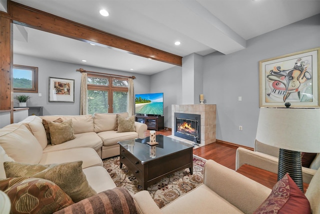 living room with wood finished floors, recessed lighting, beamed ceiling, a fireplace, and baseboards