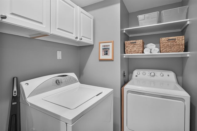 laundry area with separate washer and dryer and cabinet space
