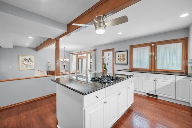 kitchen featuring black gas cooktop, dark wood-type flooring, ceiling fan, white cabinets, and beamed ceiling