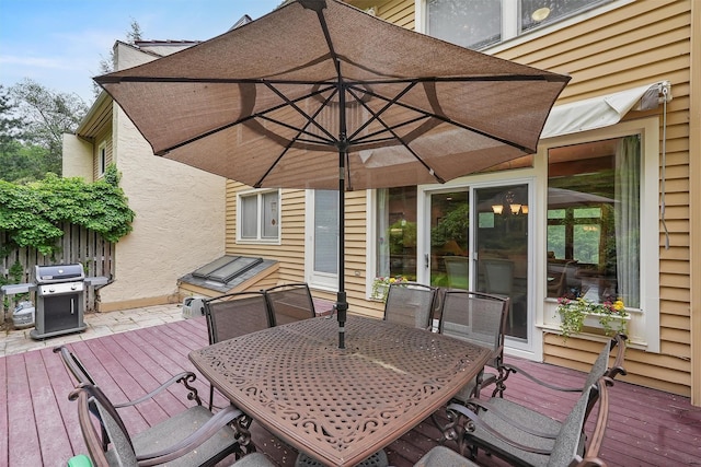 wooden terrace with area for grilling and outdoor dining space