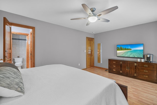 bedroom featuring wood finished floors, ensuite bathroom, and a ceiling fan
