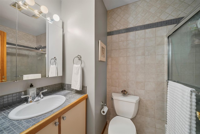 full bath featuring a tile shower, toilet, and vanity