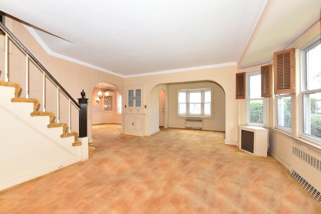 50 Fordham St, Williston Park, NY 11596 - unfurnished living room with radiator, arched walkways, light carpet, crown molding, and stairway