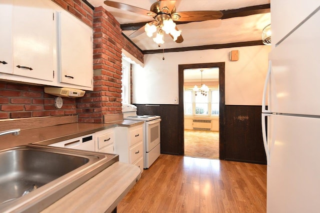 50 Fordham St, Williston Park, NY 11596 - kitchen with white appliances, a wainscoted wall, a sink, white cabinets, and radiator heating unit