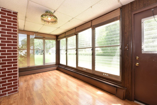 50 Fordham St, Williston Park, NY 11596 - unfurnished sunroom featuring a paneled ceiling, wood finished floors, and a baseboard radiator