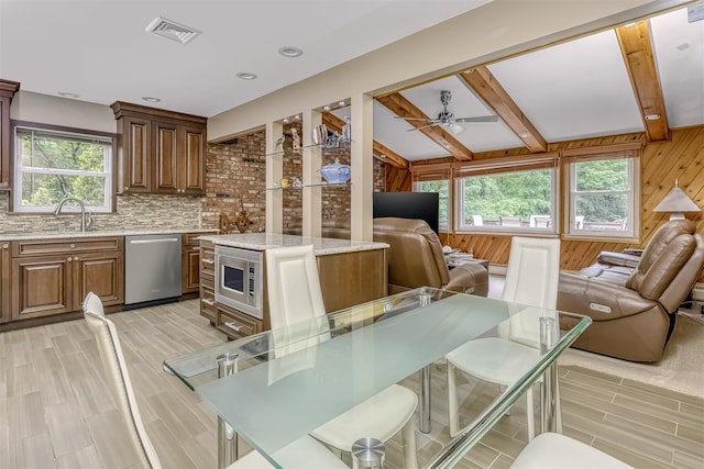 11 Kings Gate Rd, Suffern, NY 10901 - kitchen featuring stainless steel appliances, open floor plan, healthy amount of natural light, wood walls, and beamed ceiling