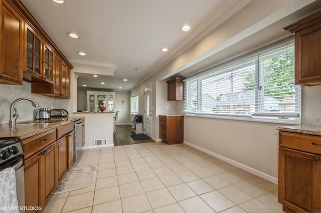 150 Arthur St, Massapequa Park, NY 11762 - kitchen featuring stainless steel appliances, healthy amount of natural light, light stone countertops, recessed lighting, and glass insert cabinets