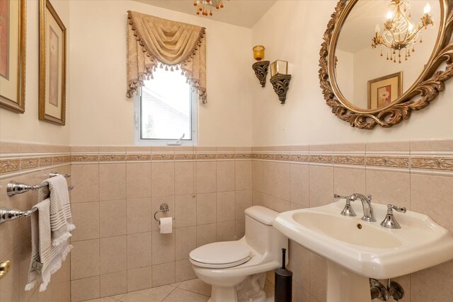 41-27 Orient Ave, Douglaston, NY 11363 - bathroom featuring tile walls, wainscoting, toilet, a sink, and tile patterned floors